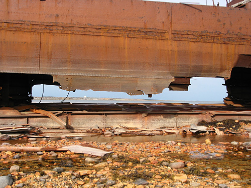 A gap in the hull frames the view westward along the shore.