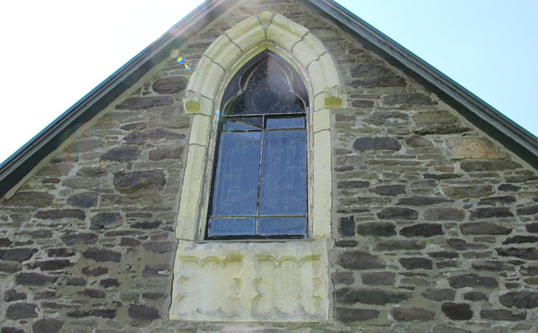 The end window illustrates the fine carving qualities of Caen stone. Note the great variety of other stone in this wall!