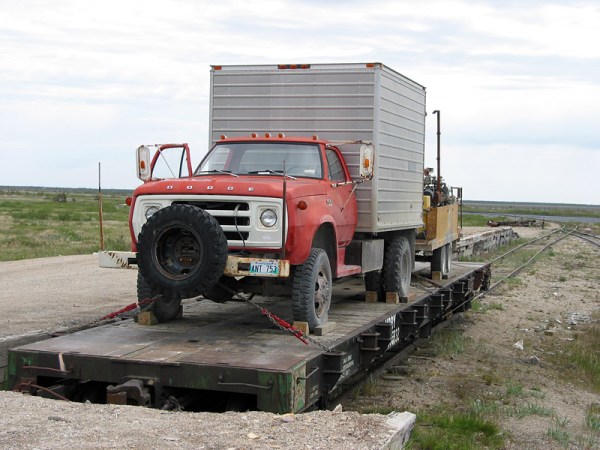 It is a challenge to get vehicles to and from Churchill. Here, the Manitoba Geological Survey's drill rig is loaded onto a flatbed car, for its travels on the Hudson Bay Railway.